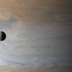 The moon Io, with Jupiter in the background.